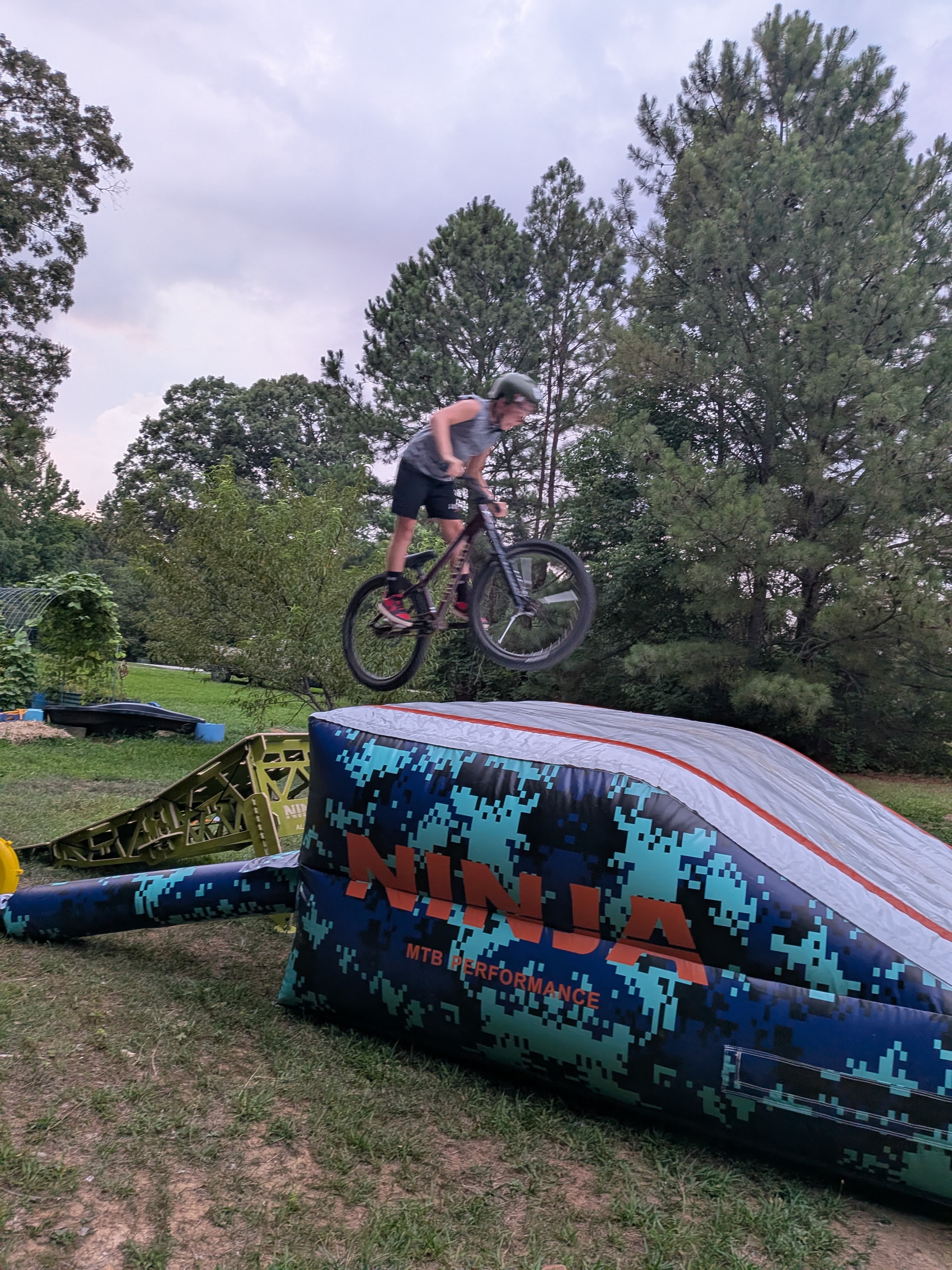 Mountain bike jump session in a backyard setup